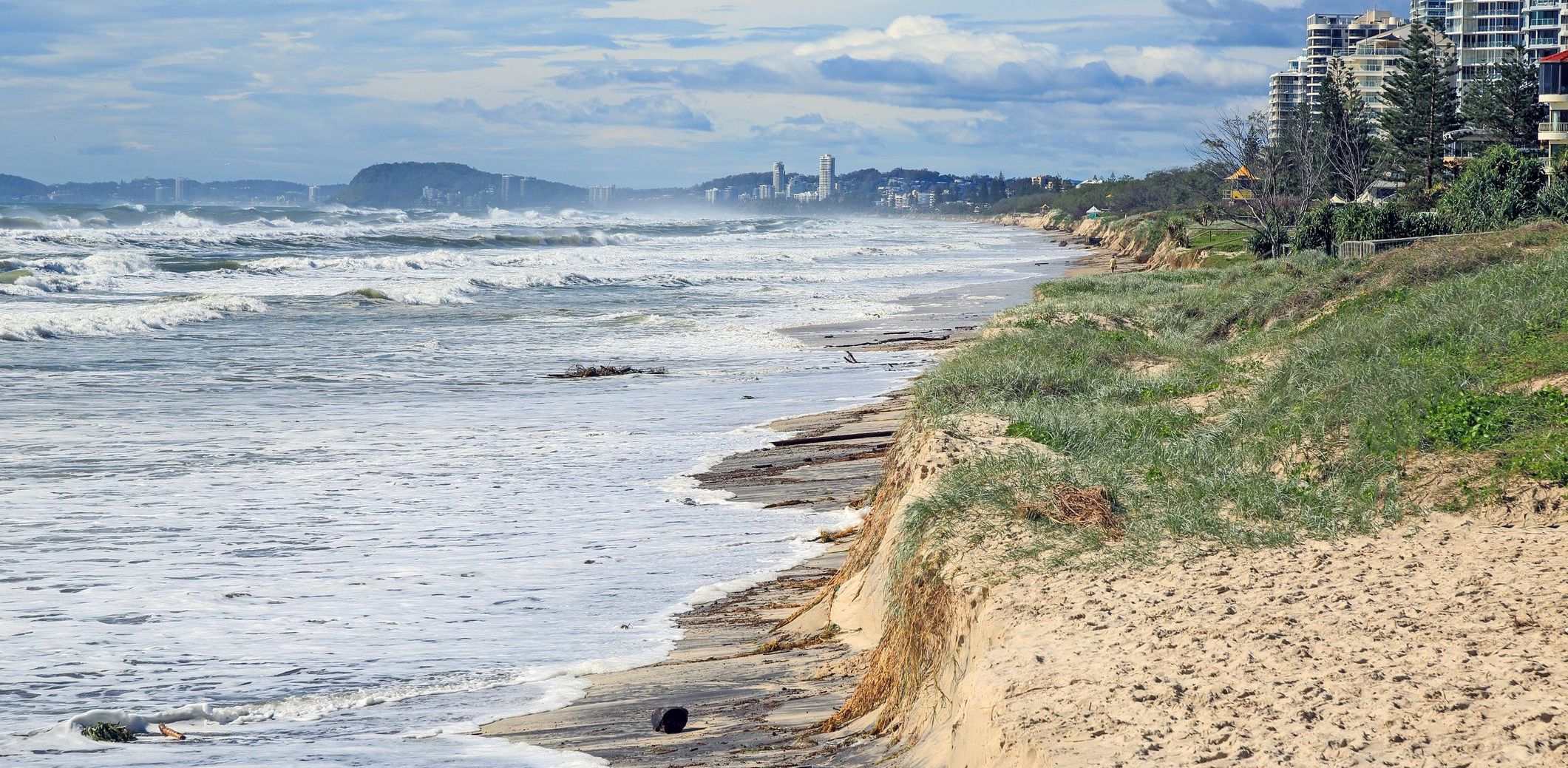 Beach erosion after storm activity Gold Coast Australia, pristine sandy beaches left with dangerous scarping and dark sands visible.