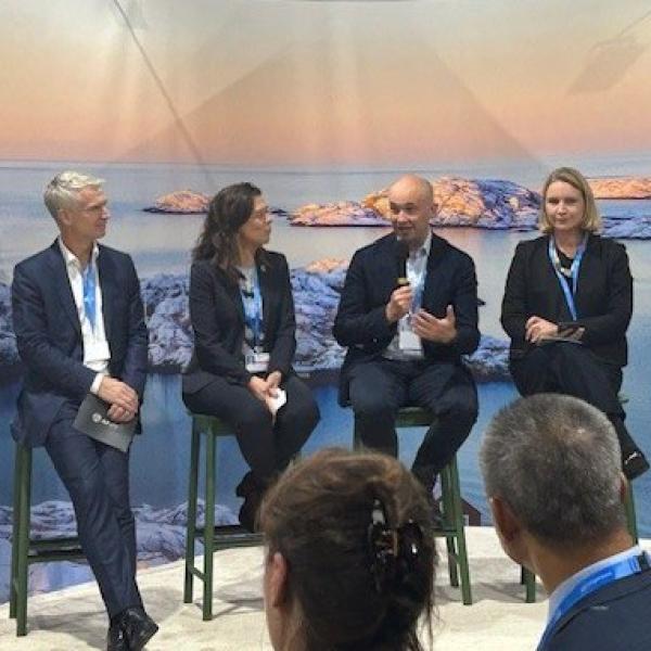 4 people sitting on a stage giving a presentation