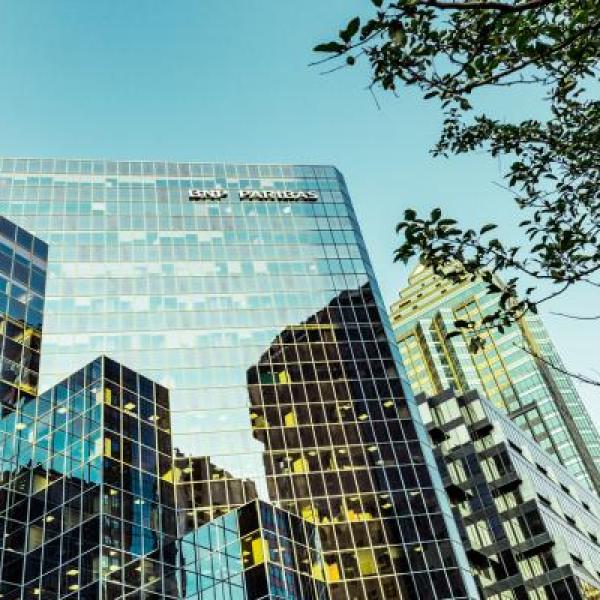 Glass office buildings among green trees