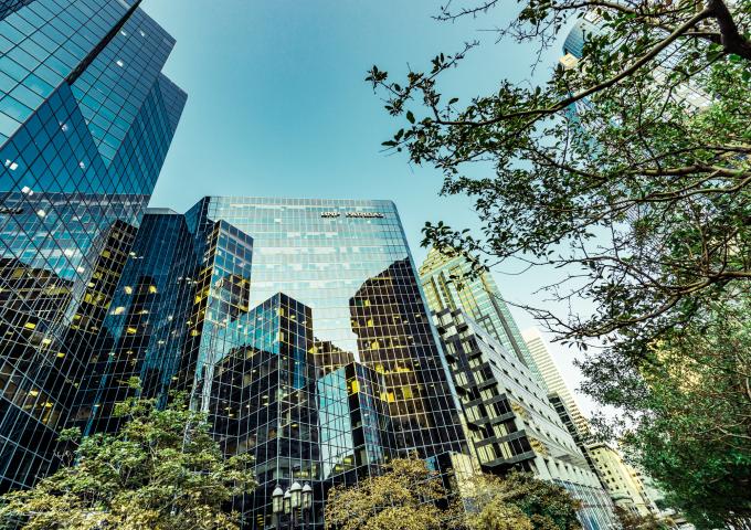 Glass office buildings among green trees